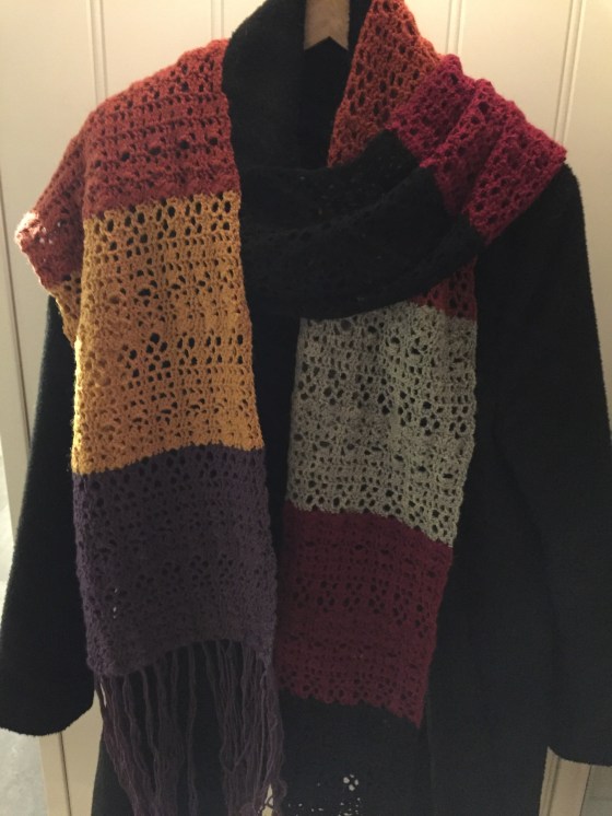 Seksfarget skjerf på svart jakke